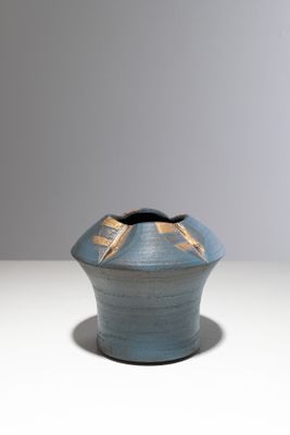 un petit vase bleu orné d'un motif doré