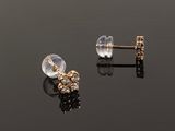 a pair of earrings on a reflective surface