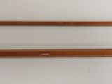 two fishing rods that are on a white surface