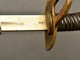 a close up of a sword with a gold handle