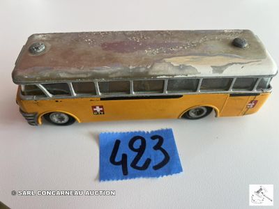 un petit bus en jouet posé à côté d'une feuille de papier