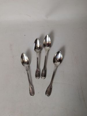 four silver spoons are arranged in a row on a white surface