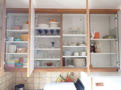 de nombreux plats et verres dans les placards de cette cuisine