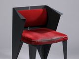 une image représentant une chaise rouge aux pieds noirs et à l'assise rouge
