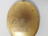 an old gold pocket watch with a chain hanging from it ' s side