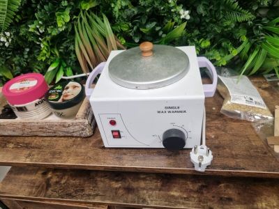 un petit poêle blanc posé sur une table en bois
