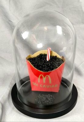a cupcake under a clochet with a candle inside of it