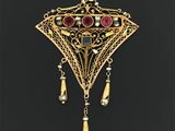 un gros plan sur un pendentif en or orné de pierres rouges et de perles