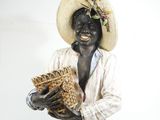 une statue représentant un homme coiffé d'un chapeau et tenant un panier