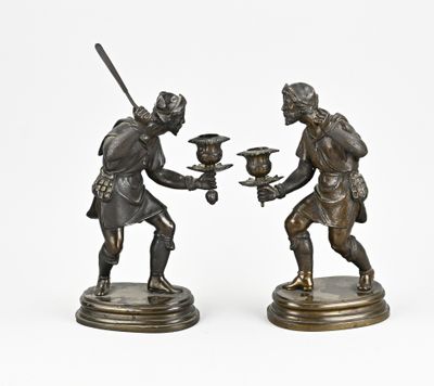 paire de figurines en bronze représentant un homme et une femme tenant un oiseau