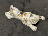 une figurine représentant un chat couché par terre