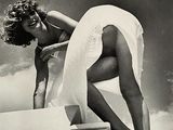 photographie en noir et blanc d'une femme en robe blanche montant un escalier