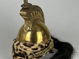 une image représentant un casque surmonté d'une plume rouge