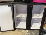 a small refrigerator with two doors open in a room