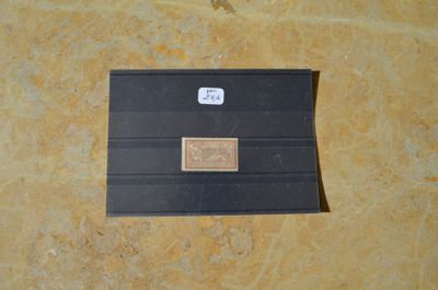 un petit morceau de papier noir sur lequel est apposé un timbre