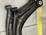 Quelqu'un est en train de travailler sur la suspension avant d'une voiture, allongé par terre.