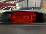 a red light on the dashboard of a car in a parking garage