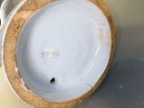 une assiette blanche à bord brun posée sur une table