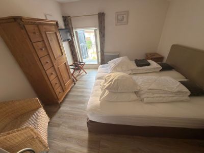 a bedroom with a bed, dresser, and a chair in it