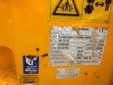 a close up of a yellow machine with a warning sticker on it