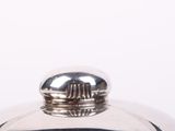 a silver pot with a lid on a white table