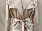 an image of a mannequin wearing a beige jacket with a bow tie