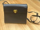 a black purse sitting on top of a wooden table