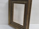 a gold picture frame with a decorative pattern on it