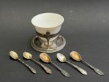 five spoons and a bowl sitting on a table