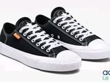 des baskets noires et blanches avec des lacets blancs sur fond blanc