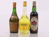 three bottles of liquor are lined up on a white surface