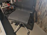 a desk with a computer and a chair in the corner
