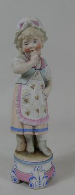 une figurine représentant une petite fille debout sur une boîte