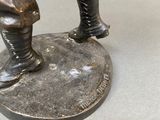 a bronze statue of a man holding a baseball bat
