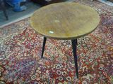 une petite table en bois posée sur un tapis dans une pièce