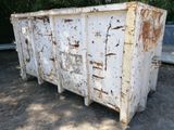 a white dumpster sitting in the middle of a dirt field