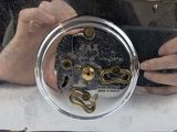 someone is taking a picture of a clock with their reflection in the mirror