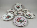 several plates with floral designs are arranged on a white surface
