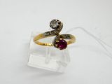 a close up of a gold ring with a red stone on it