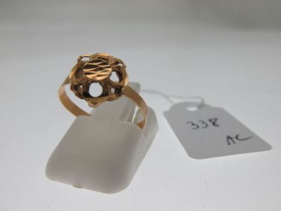 une image d'une bague en or sur une surface blanche avec une étiquette de prix