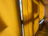 a room with a checkered floor and yellow curtains