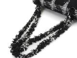 black and white checkered purse with fringes on a white background