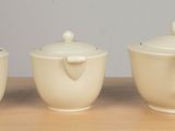 three white teapots sitting on a table next to each other