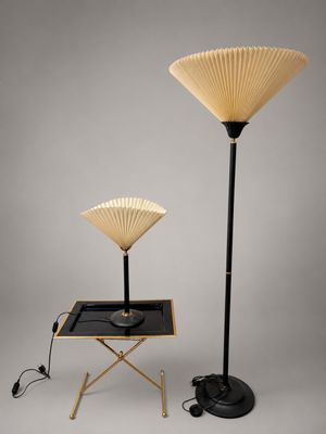 une paire de lampes en forme d'éventail, noires et dorées, montées sur un pied