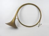 une vieille trompette en laiton avec un long pavillon, sur fond blanc