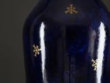 a blue vase with gold snowflakes on it