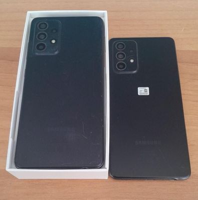 an open box with a black phone sitting on top of a wooden table