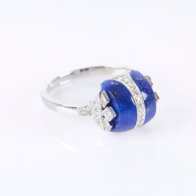 a close up of a ring with a blue stone and diamonds