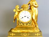 une horloge en or représentant une femme tenant un panier de fleurs