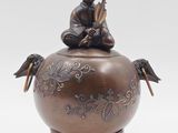 a small statue of a person sitting on top of a pot